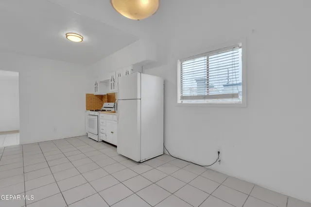 a kitchen with white cabinets and white appliances