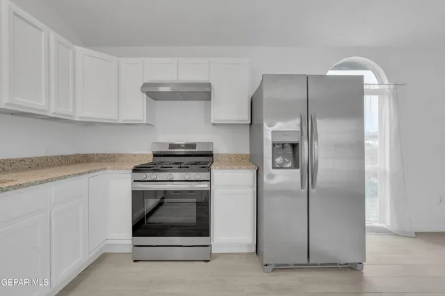 a kitchen with cabinets and stainless steel appliances