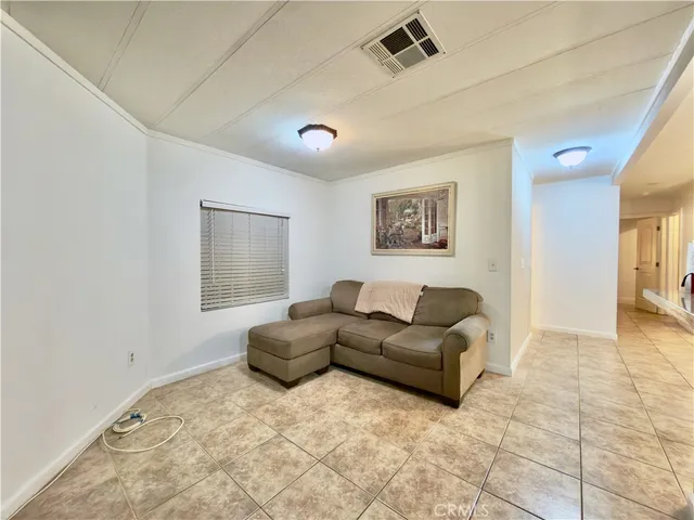 a view of an empty room with window and a kitchen