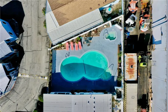 an aerial view of a swimming pool with outdoor seating