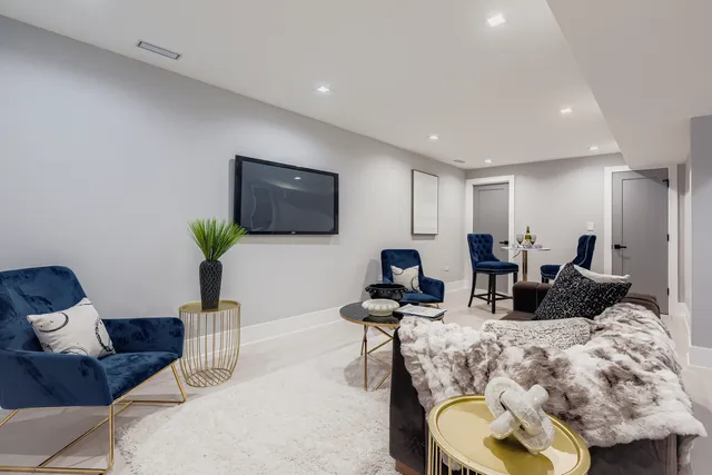 a living room with furniture a flat screen tv and a potted plant