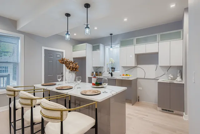 a kitchen with a dining table chairs sink and stove
