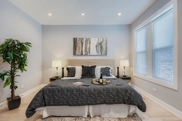 a bedroom with a large bed and a potted plant