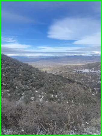 a view of dirt field with trees in the background