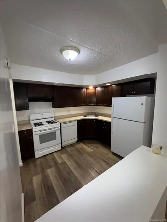 a kitchen with a refrigerator sink and wooden cabinets