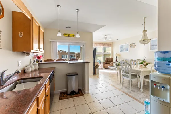 a kitchen with kitchen island granite countertop a sink counter and chairs