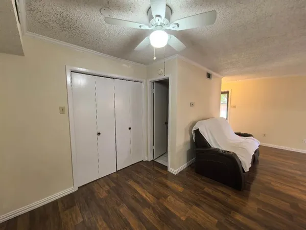 a room with wooden floor and a ceiling fan