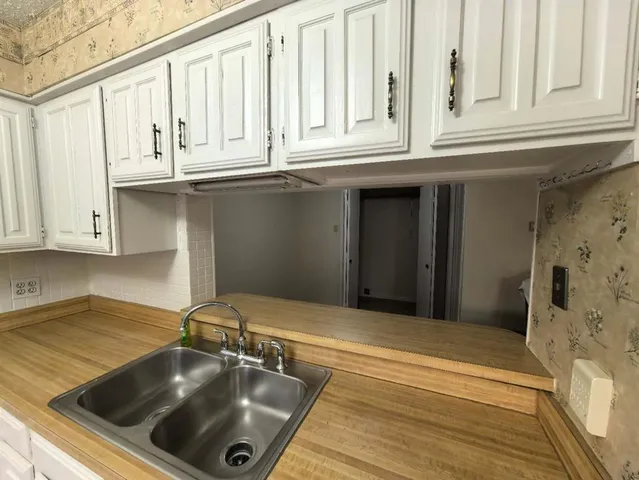 a kitchen with granite countertop a sink and cabinets