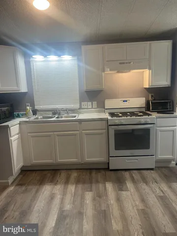 a kitchen with a stove sink and cabinets