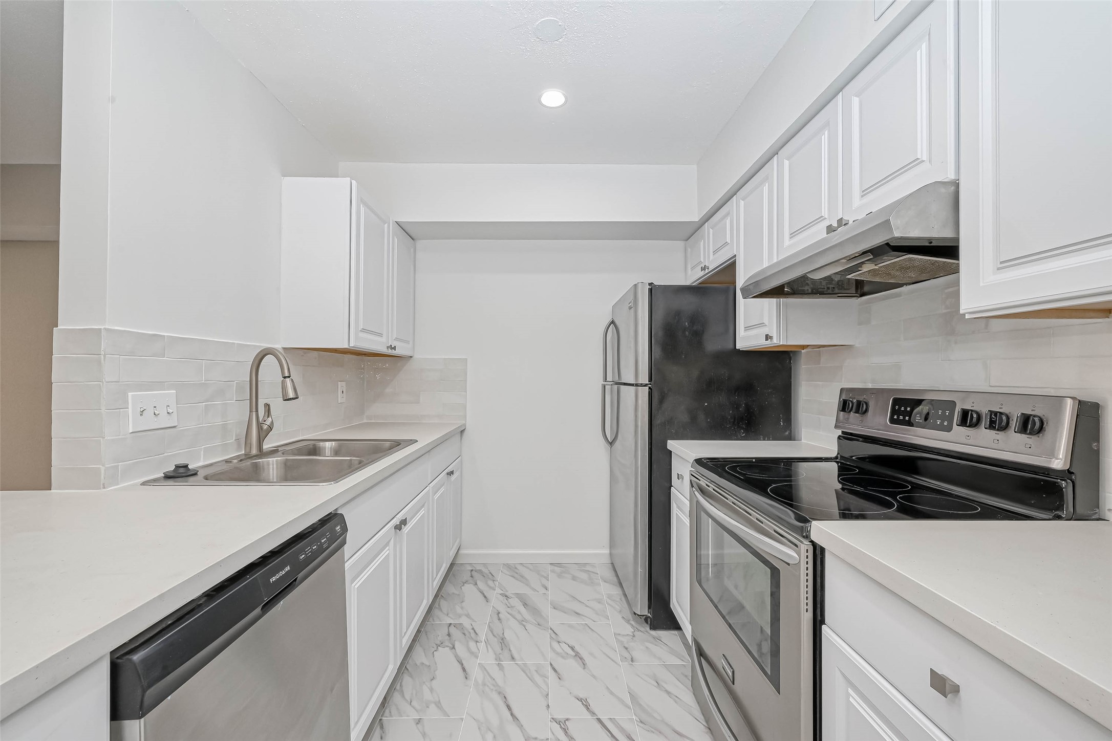 a kitchen with stainless steel appliances granite countertop a sink stove and refrigerator