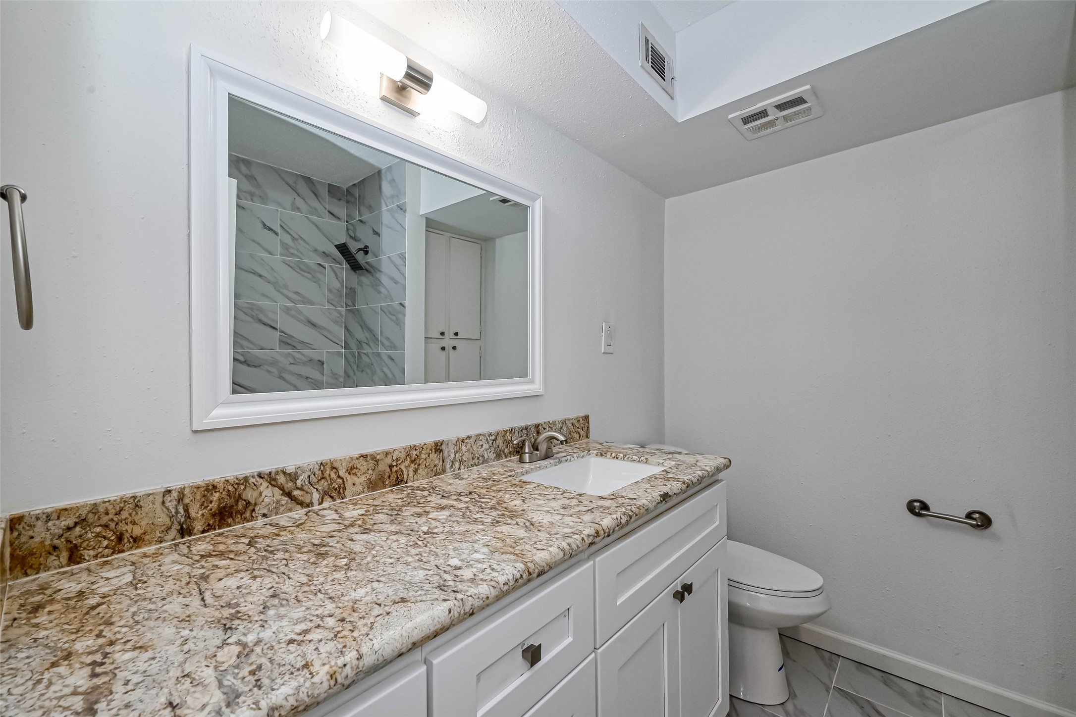 4645 Wild Indigo Street, Unit 375 Houston, TX 77027 - Photo 16 of 27 a bathroom with a granite countertop sink and a toilet