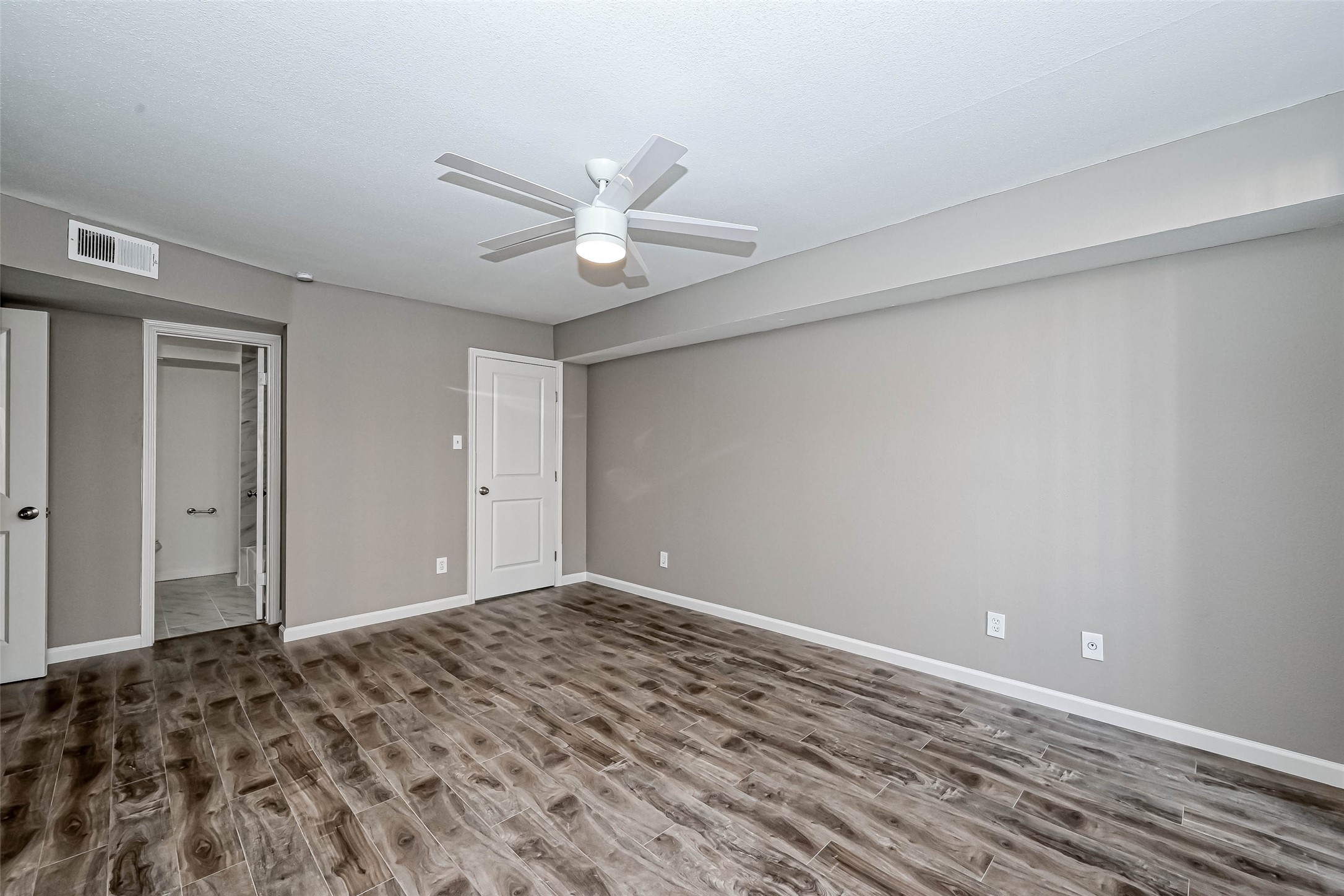 4645 Wild Indigo Street, Unit 375 Houston, TX 77027 - Photo 18 of 27 a view of a big room with wooden floor and a ceiling fan