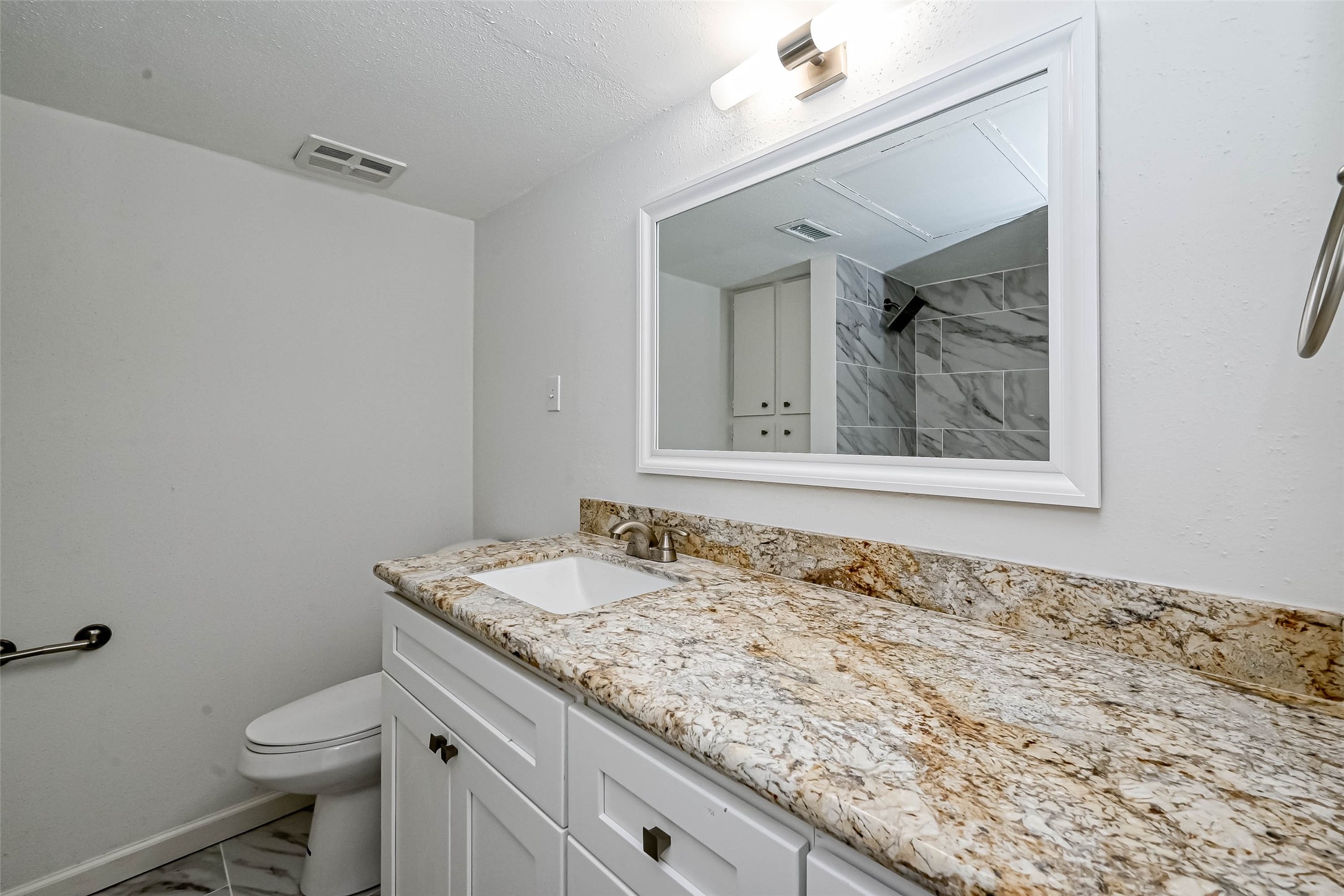 4645 Wild Indigo Street, Unit 375 Houston, TX 77027 - Photo 21 of 27 a bathroom with a granite countertop sink toilet and mirror
