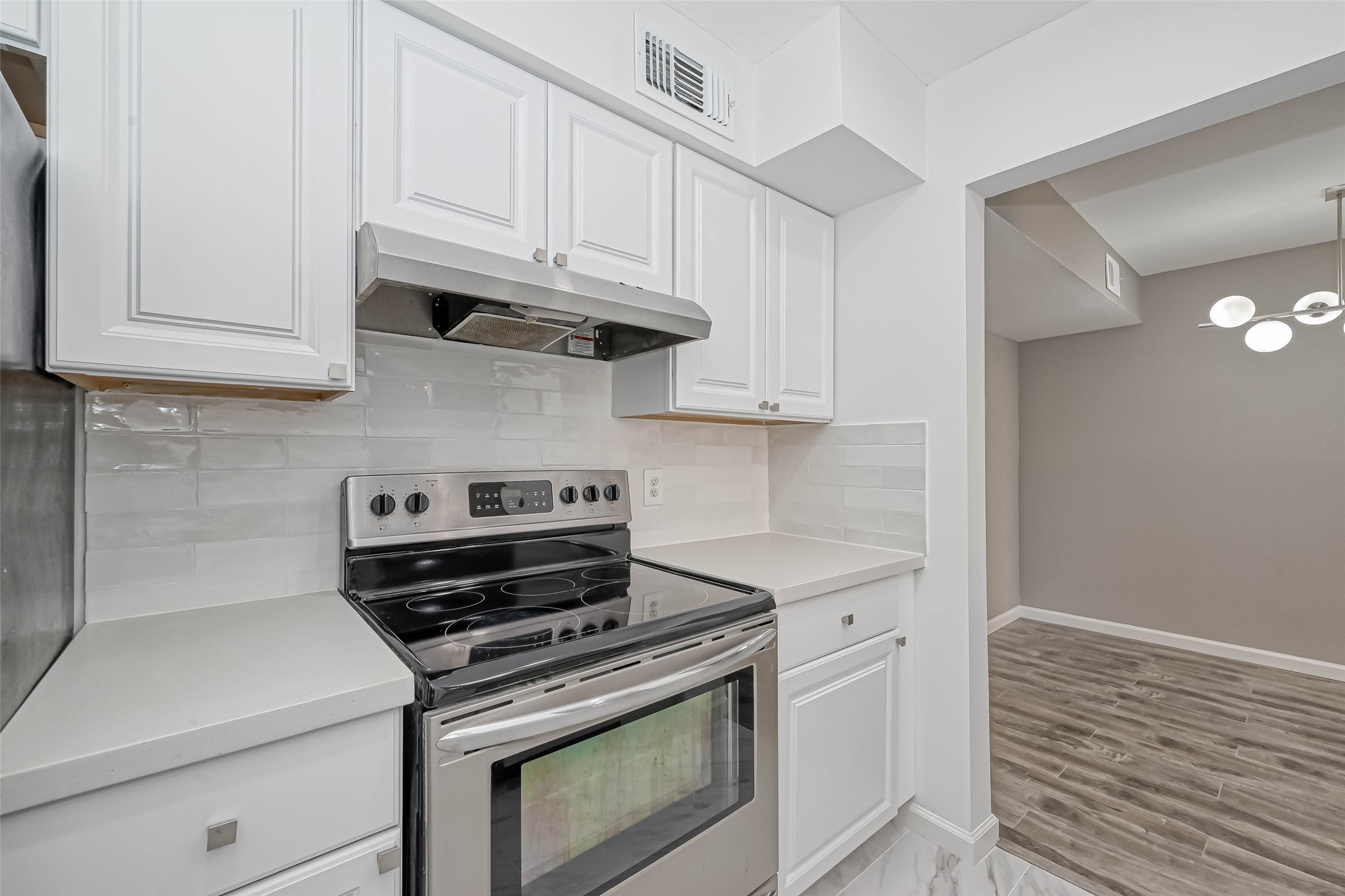 4645 Wild Indigo Street, Unit 375 Houston, TX 77027 - Photo 6 of 27 a kitchen with white cabinets and appliances