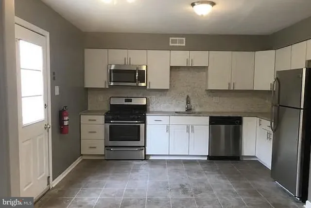 a kitchen with stainless steel appliances a stove a sink and a microwave