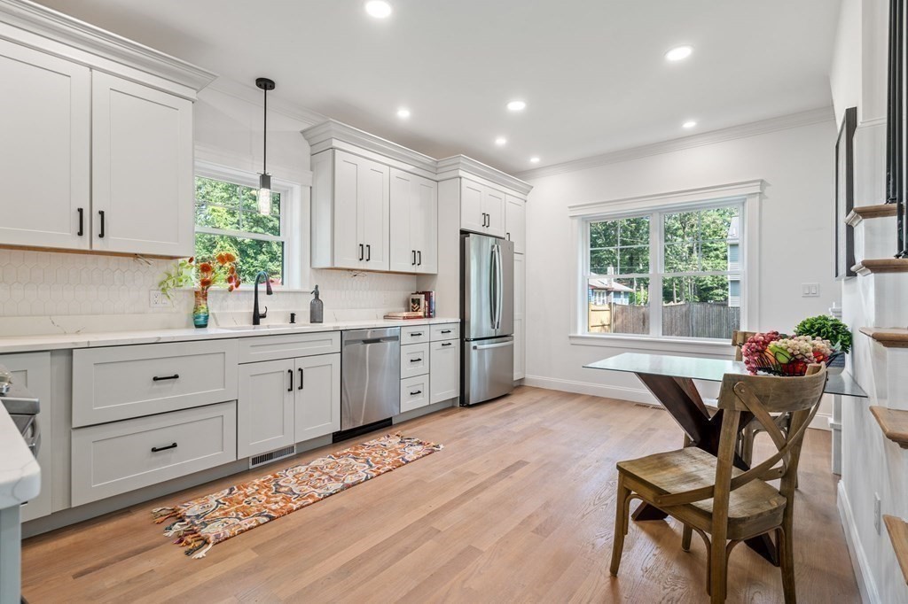 504 Hudson Road Sudbury, MA 01776 - Photo 14 of 42 a kitchen with a table chairs a refrigerator and cabinets
