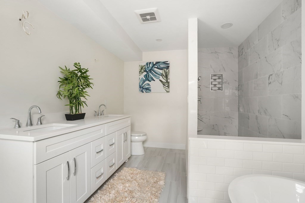 504 Hudson Road Sudbury, MA 01776 - Photo 28 of 42 a bathroom with a double vanity sink toilet and shower