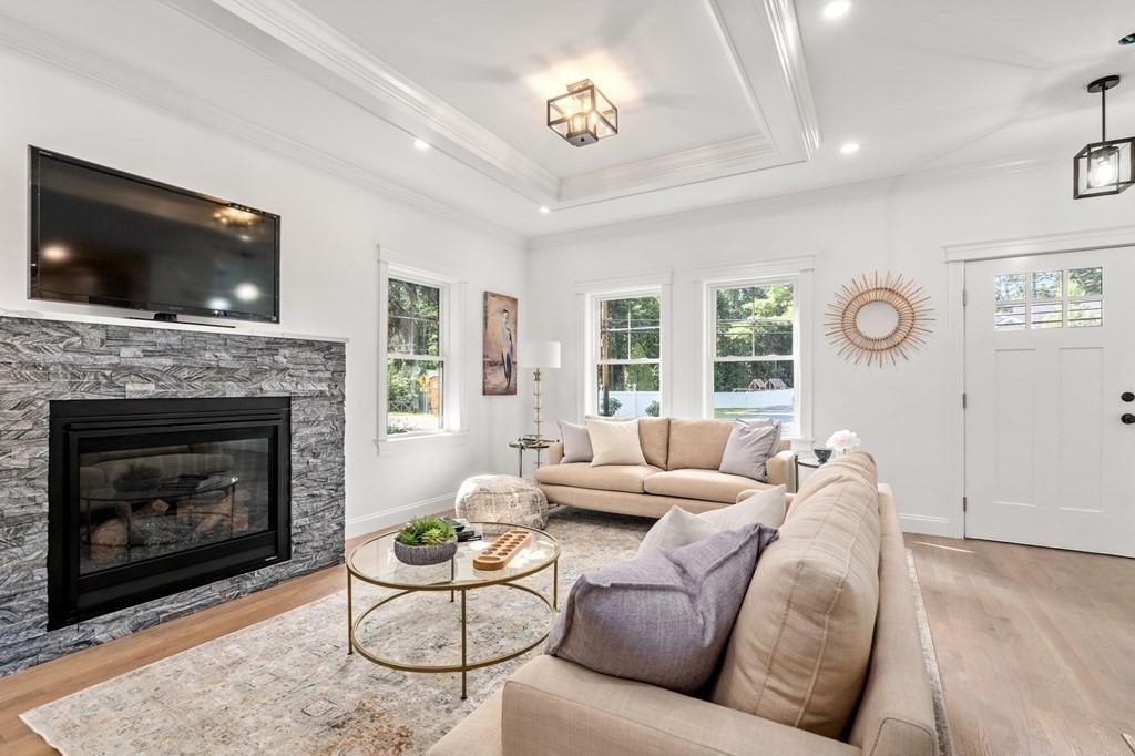 504 Hudson Road Sudbury, MA 01776 - Photo 9 of 42 a living room with furniture a flat screen tv and a fireplace