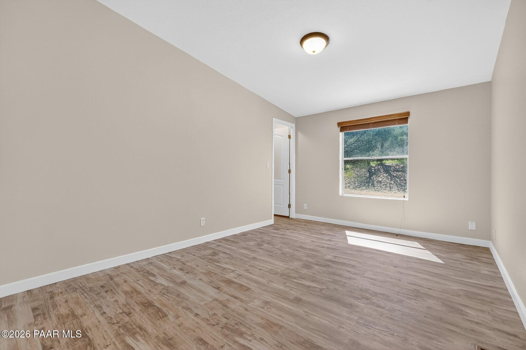 13230 East Main Street Mayer, AZ 86333 - Photo 22 of 32 an empty room with wooden floor and windows