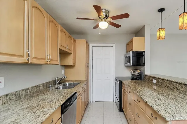 a kitchen with stainless steel appliances granite countertop a sink a stove and a microwave oven
