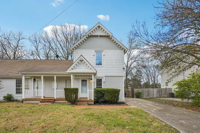 a view of an empty room with wooden floor fireplace and a window