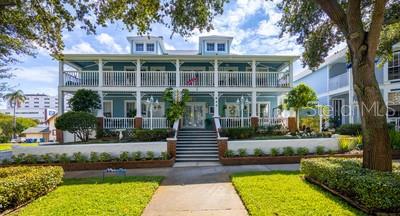 a front view of a house with a yard and potted plants
