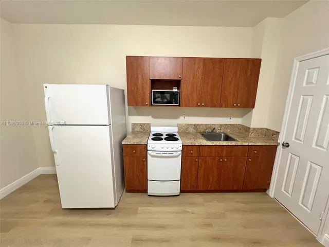 a kitchen with a refrigerator sink stove and cabinets