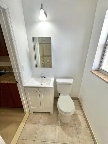 a bathroom with a toilet a sink and mirror