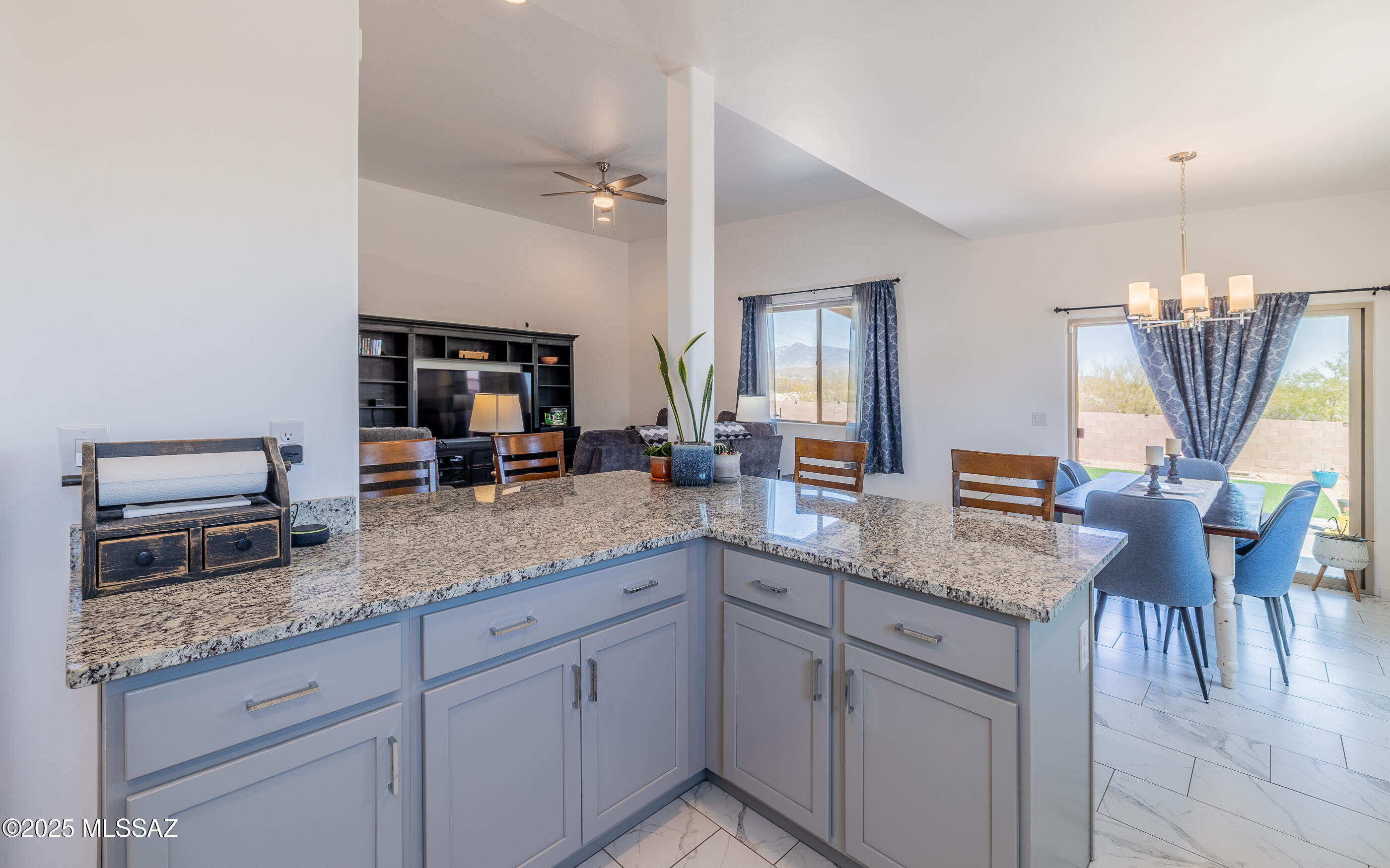 12123 Creosote Valley Road Vail, AZ 85641 - Photo 12 of 46 a kitchen with granite countertop a sink a center island a stove and a wooden cabinets