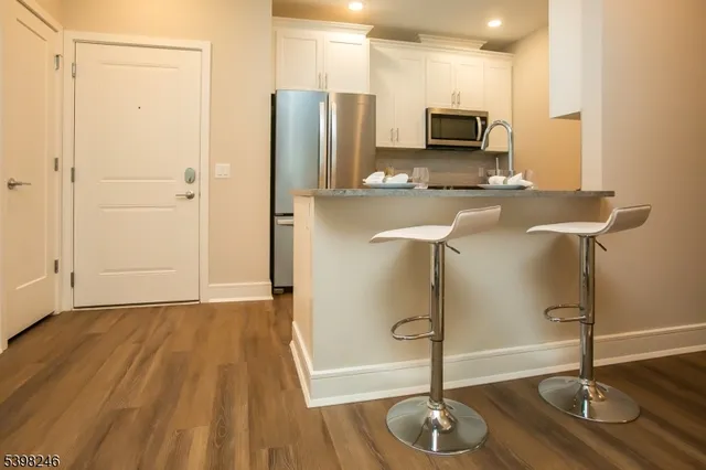 a kitchen with stainless steel appliances granite countertop a refrigerator and a sink