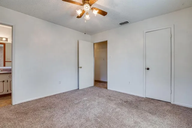 a view of an empty room with a chandelier fan