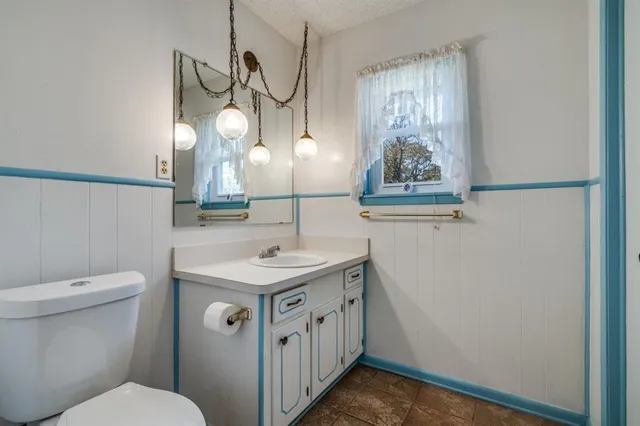 a bathroom with a toilet sink and mirror