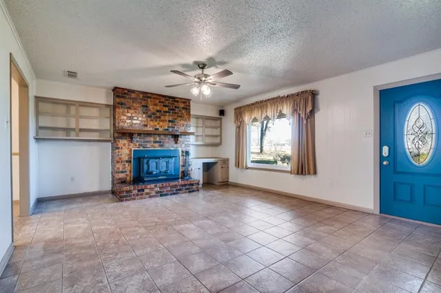 an empty room with windows and fireplace