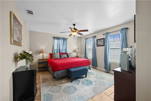 a spacious bedroom with a bed and a potted plant