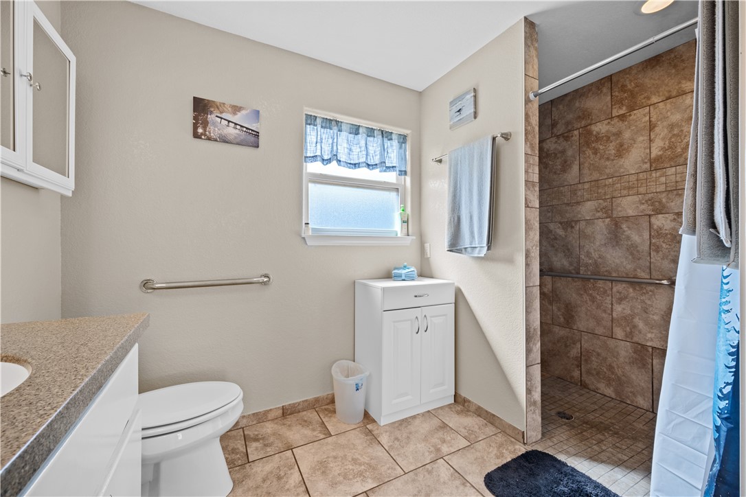 464 Sunset Ingleside, TX 78362 - Photo 18 of 35 a white toilet sitting next to a bathroom sink and a shower