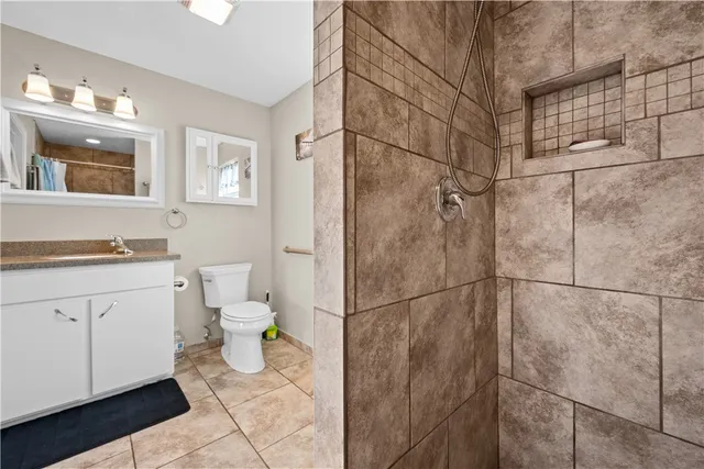 a bathroom with a granite countertop sink toilet and shower