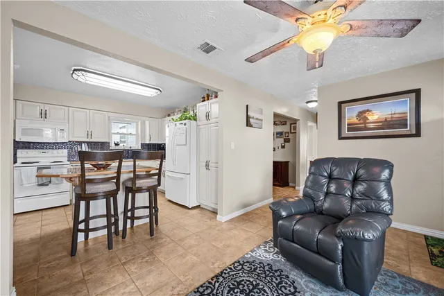 a living room with furniture a dining table and kitchen view