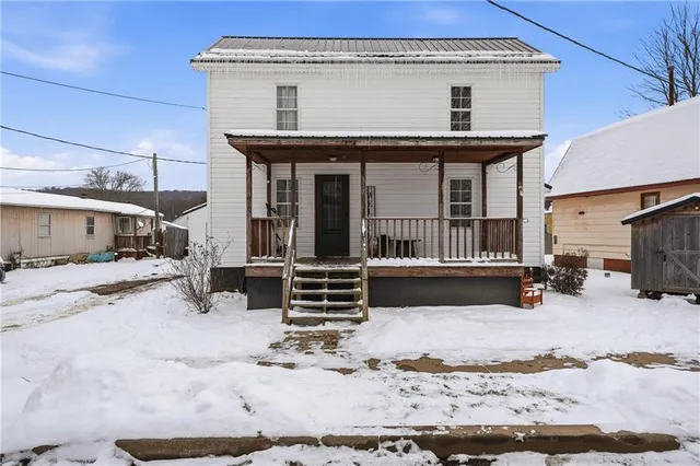 a view of a house with a yard covered in snow
