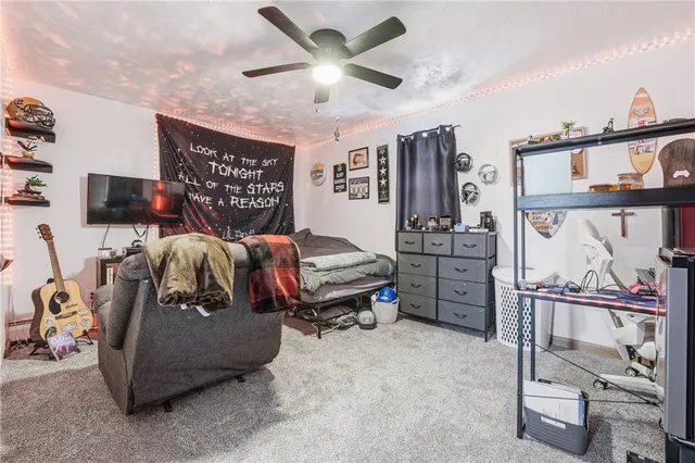 a bedroom with furniture a flat screen tv and a window