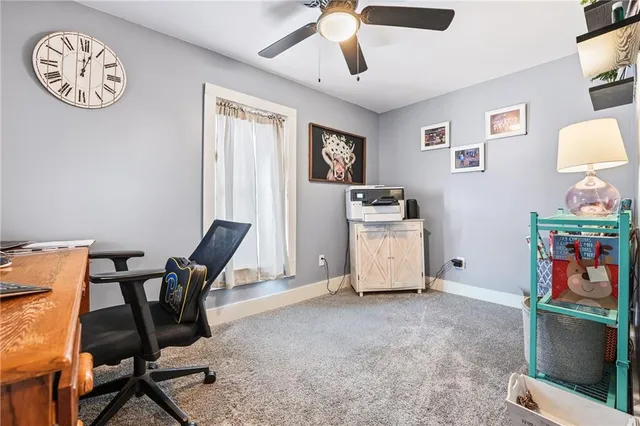 a view of workspace with lounge chair and ceiling fan