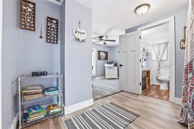 a view of a hallway to a livingroom with wooden floor
