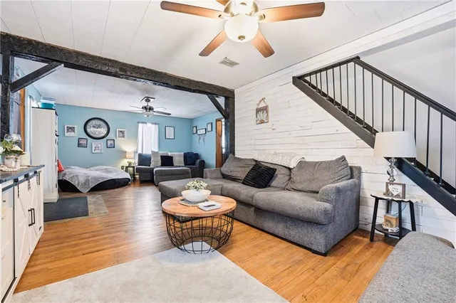 a living room with furniture kitchen view and a chandelier