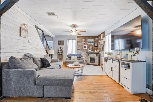 a living room with stainless steel appliances furniture a rug and a kitchen view