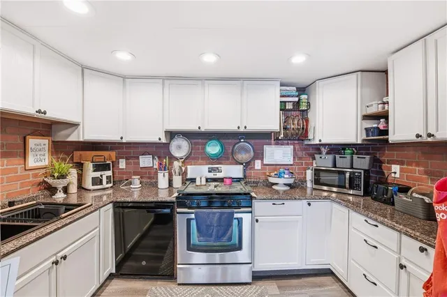 a kitchen with kitchen island granite countertop a sink and a stove