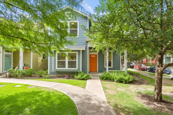 a front view of a house with a yard and trees