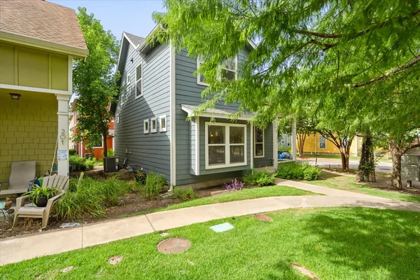 a front view of a house with a yard and potted plants