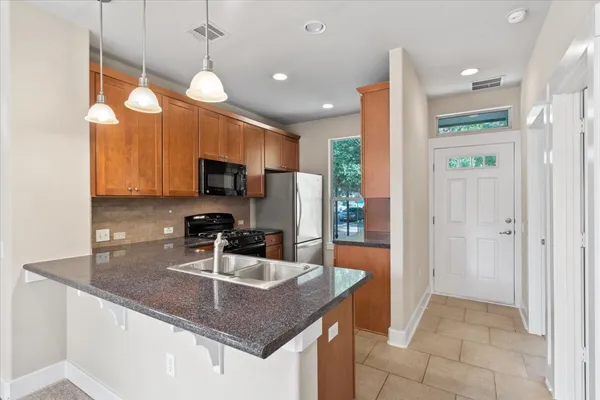 a kitchen with granite countertop white cabinets and stainless steel appliances