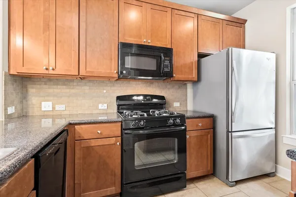 a kitchen with granite countertop a sink a window and stainless steel appliances