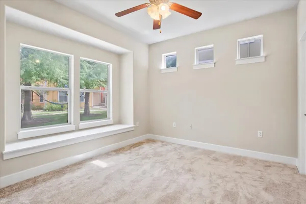 an empty room with closet and windows