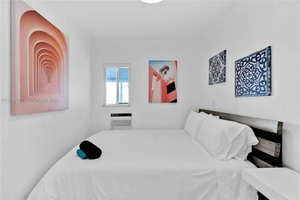 a bedroom with a bed and a painting on the wall